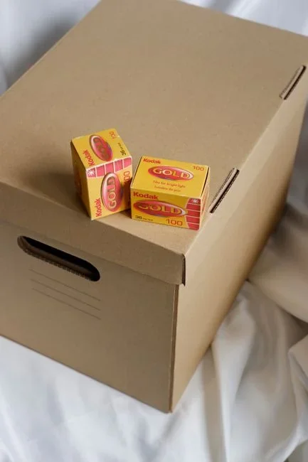 A vintage-style cardboard box of powdered borax laundry booster next to a container of boric acid powder on a wooden shelf