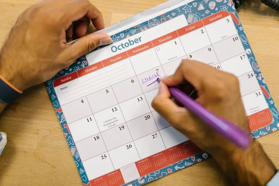 Hand writing a date with a marker on a freezer bag of portioned raw chicken
