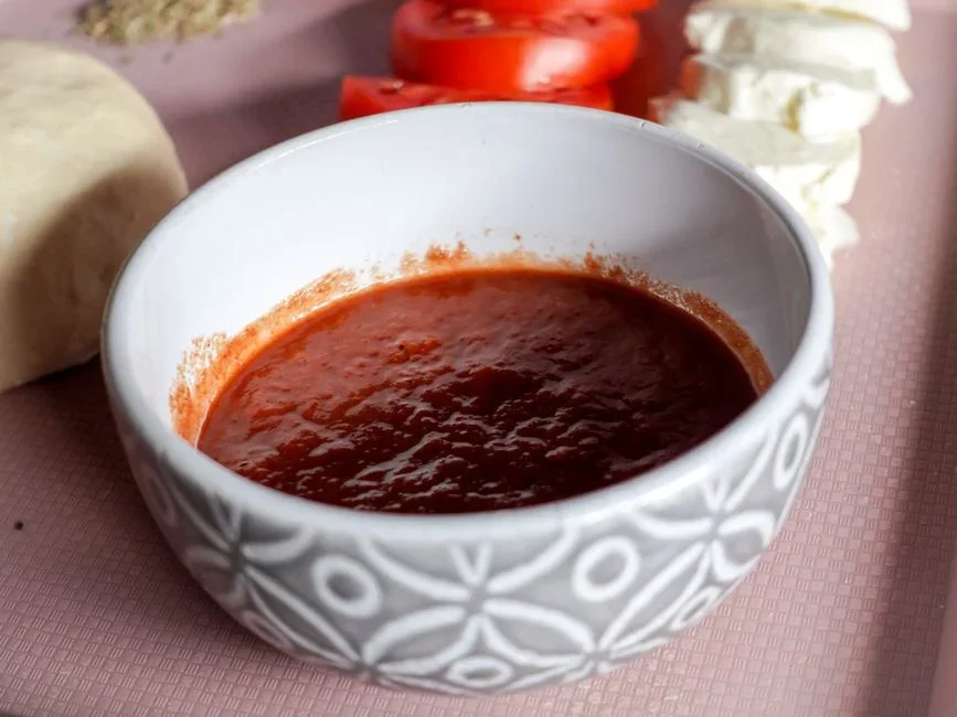 Red tomato sauce simmering and bubbling in a black cast iron skillet on a stovetop