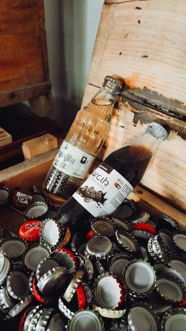 An opened glass bottle of pure maple syrup stored upright inside a refrigerator door