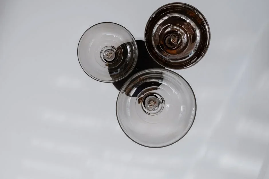 Three glass bowls of white powder — coarse Epsom salt crystals, fine baking soda, and borax laundry powder — lined up side by side on a wooden kitchen counter