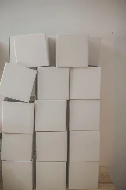 A completed Corsi-Rosenthal box air cleaner made from a box fan and four square MERV-13 furnace filters taped into a cube, running on a living room floor