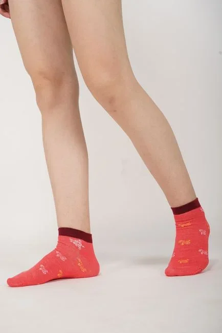 Close-up of a cluster of small red raised chigger bite welts along a person's sock line just above the ankle