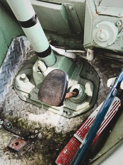 Close-up of a hand pushing the damper lever on a white metal floor register to close it in an empty carpeted spare bedroom