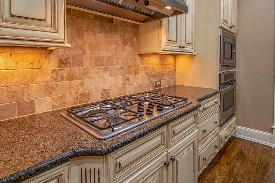 Total release fogger aerosol can standing on a kitchen floor beside a gas stove with a pilot light
