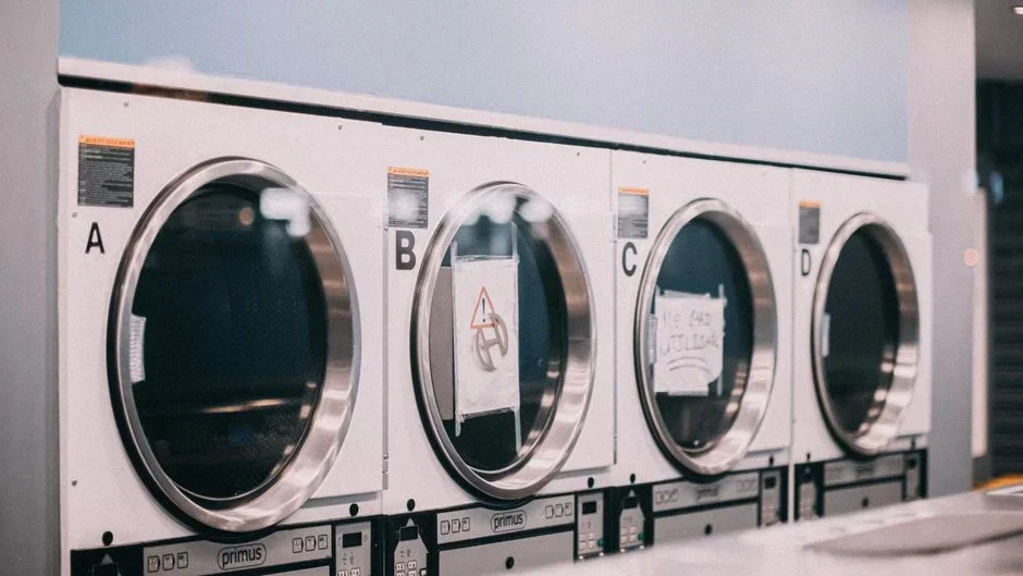 Close-up of the nameplate label on the back of a clothes dryer showing voltage and wattage ratings