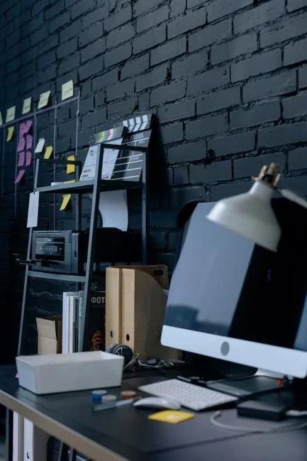 Overhead view of a home office desk with a printer, router, external hard drive and monitor, each cord labeled with a small paper sticky note showing handwritten wattage numbers