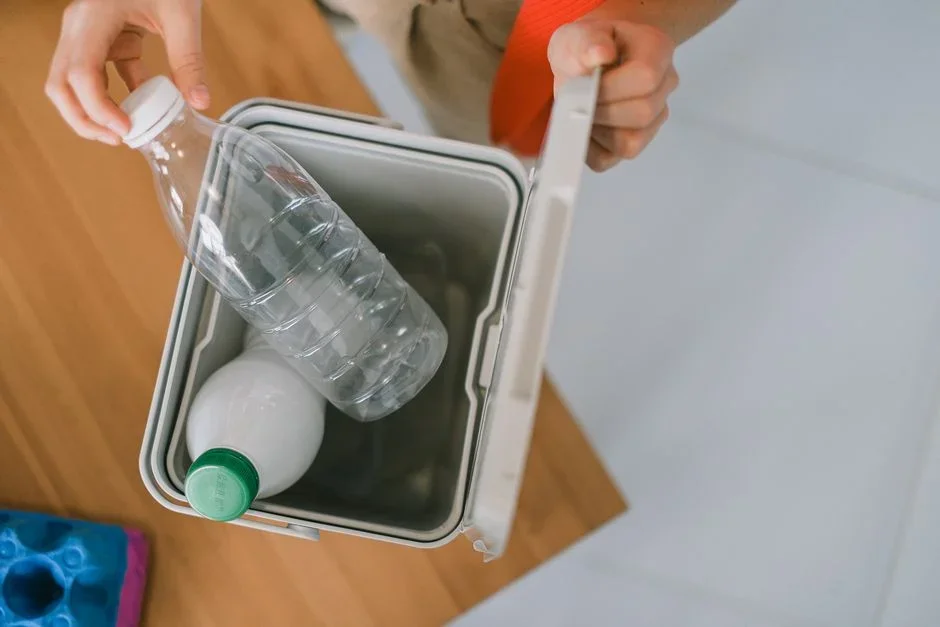 Clear plastic storage bin of folded sweaters opened on a concrete basement floor with condensation on the underside of the lid