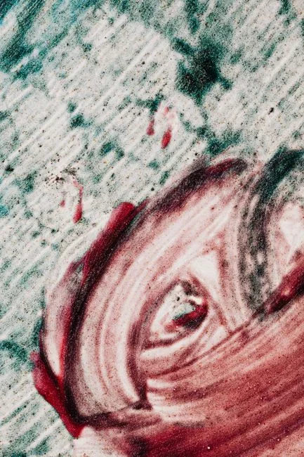 Pink and salmon-colored bacterial film smeared along the back inside wall of a white toilet bowl just above the waterline